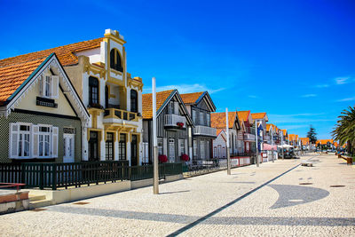 Typical buildings in costa nova beach against blue sky on sunny day