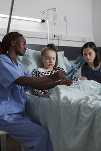 Portrait of doctor examining patient in hospital