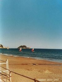 Boats in sea against clear sky