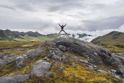 Rear view of man climbing on mountain against sky