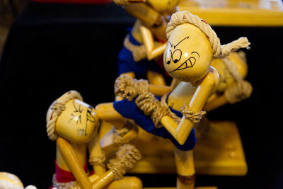 Close-up of wooden figurines boxing against black background