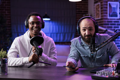 Portrait of vloggers sitting at studio