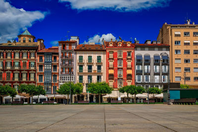 Buildings in city against cloudy sky