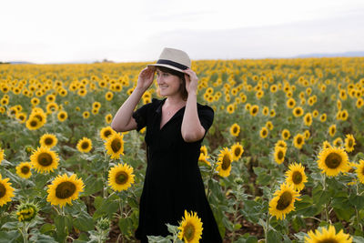 Full length of woman standing on sunflower land