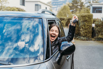 Portrait of laughing woman sitting in car