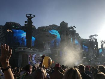 People enjoying at music concert against sky