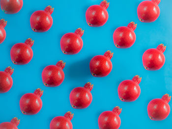 Directly above shot of red berries against blue background