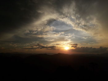 Scenic view of dramatic sky over silhouette landscape