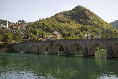 Bridge over river against mountain