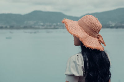 Rear view of woman looking at sea against sky