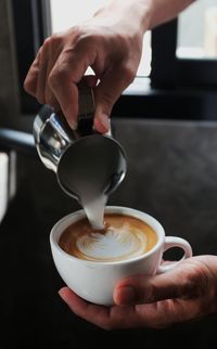 Midsection of man holding coffee cup