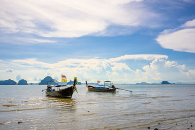 Boats moored in sea against sky