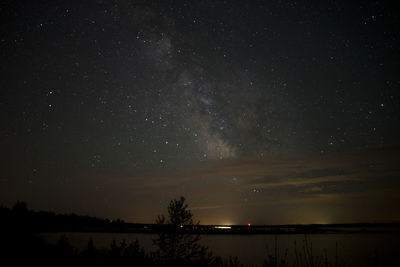 Scenic view of landscape against star field at night