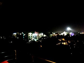 Illuminated cityscape against sky at night