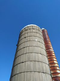 Low angle view of silo against clear blue sky