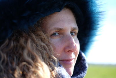 Close-up of smiling woman wearing fur coat looking away