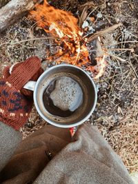 Tourist drink a coffee near campfire