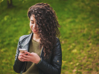 Close-up of young woman using mobile phone at park