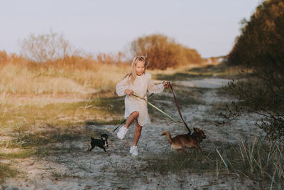 Full length of woman with dog on field