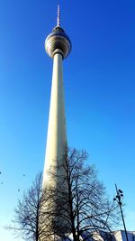 Low angle view of communications tower against blue sky