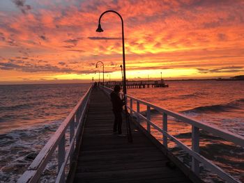 Pier on sea at sunset