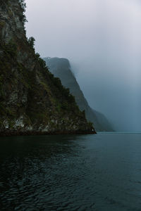 Scenic view of sea and mountains against sky