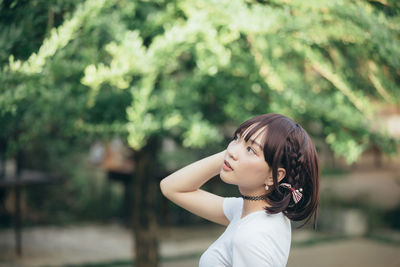 Side view portrait of a young woman standing outdoors