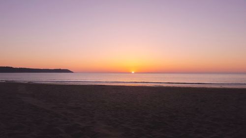 Scenic view of sea against clear sky during sunset