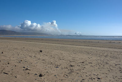 Scenic view of beach against blue sky