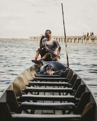 Full length of man sitting on pier against sky