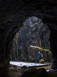 View of tourist in rock crevice at winter
