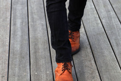 Low section of man standing on floorboard