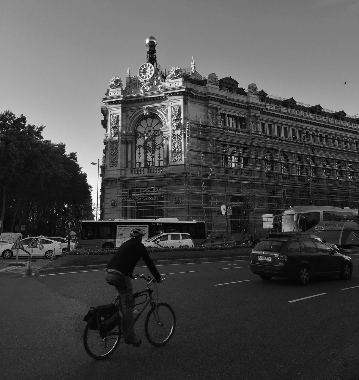 building exterior, architecture, transportation, land vehicle, built structure, mode of transport, bicycle, street, city, car, road, men, travel, city street, riding, city life, clear sky, walking