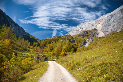 Road amidst green landscape against sky