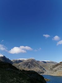 Scenic view of snowcapped mountains against blue sky