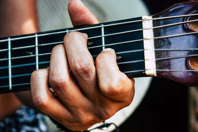 Close-up of hand playing guitar