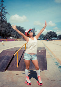 Full length of smiling young woman wearing roller skates