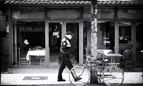 Man with bicycle standing in front of building