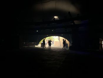 Rear view of silhouette people walking in illuminated building