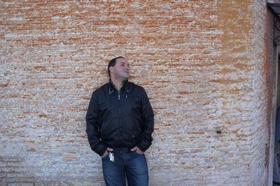 Man standing against brick wall