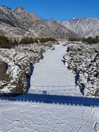 Scenic view of snowcapped mountains against clear blue sky