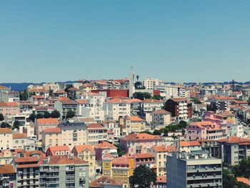 Buildings in city against clear blue sky