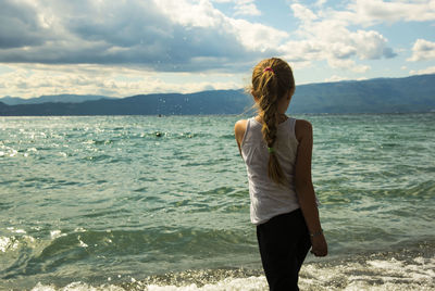 Rear view of woman standing on beach