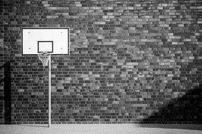 Low angle view of basketball hoop against brick wall