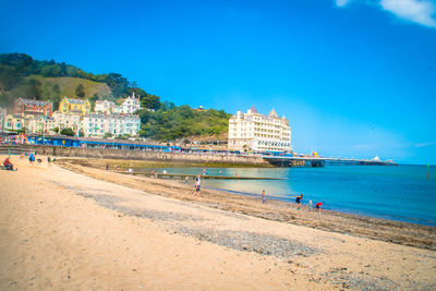 People on beach against blue sky
