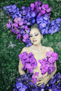 Portrait of woman against purple flowering plants