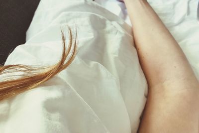 Close-up of woman hand on bed