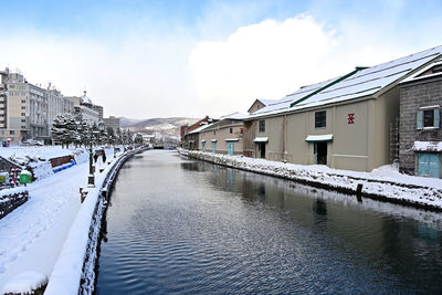 Canal amidst buildings against sky