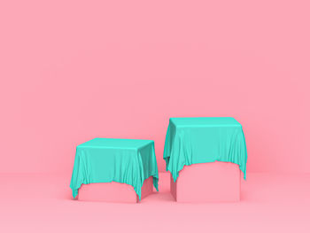 Close-up of empty chairs against pink background