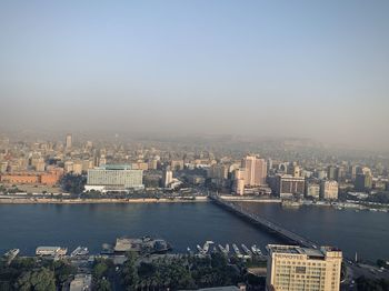 Scenic view of river and buildings against clear sky